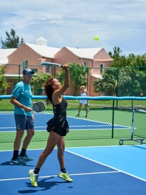 Two people are on a court playing pickleball