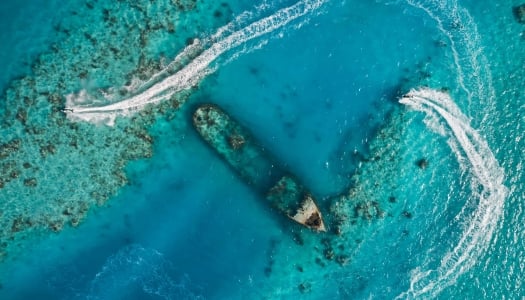 Aerial of jetskis circling around a shipwreck