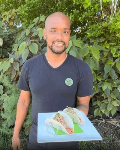 A man is holding vegan food on a plate.