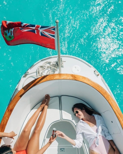 Two people relaxing and sharing a drink on a boat floating in Bermuda