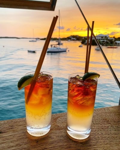 Two cocktails on a table near a harbour