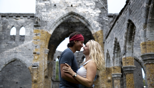 A couple are posing in front of the Unfinished Church