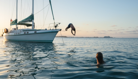 A group of people are jumping off a boat charter.
