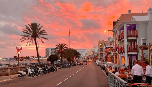 A beautiful pink sunset on a busy street in Bermuda.