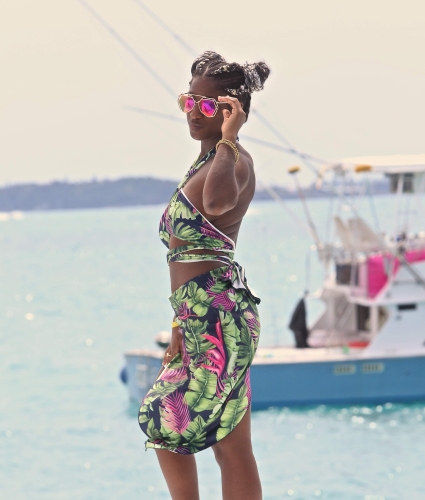 A woman posing with sunglasses near sailboats in Bermuda