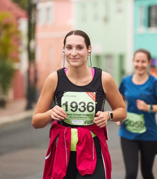 A woman is smiling while running a marathon.