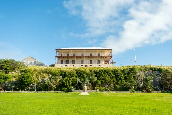 An exterior view of the National Museum of Bermuda, with a sprawling lawn and tall hedge