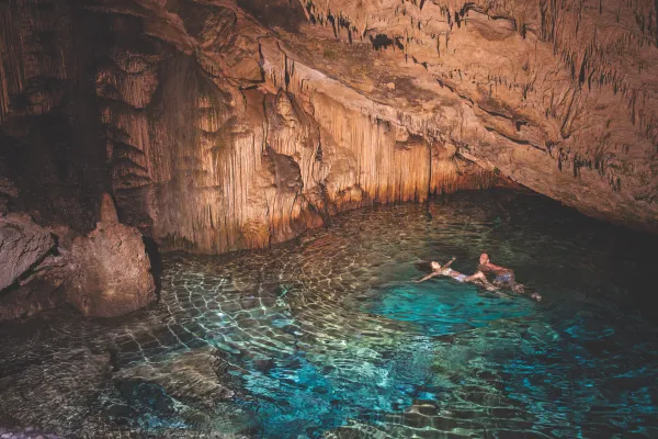 A couple swimming in a cave grotto in Bermuda