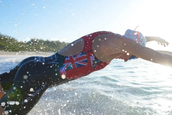 A man in a UK singlet dives into the water in Bermuda