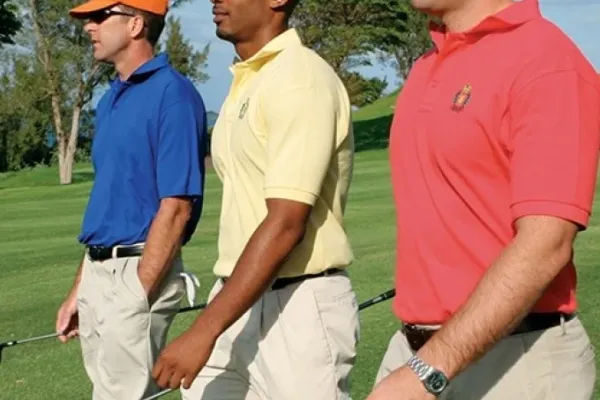 Three men walking on the fairway of a Bermuda golf course