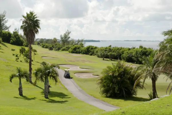 A cart drives down a tree-lined path at Ocean View golf course in Bermuda