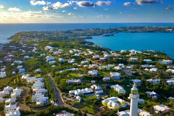 An aerial view of a Bermuda town with coastal houses and a lighthouse