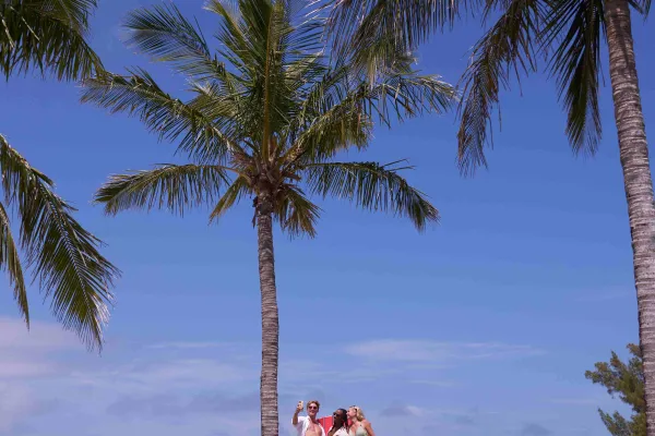 A group of friends are posing on a large chair.