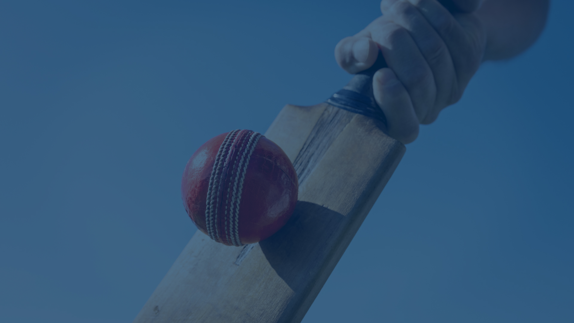 Closeup of a cricket bat hitting a cricket ball