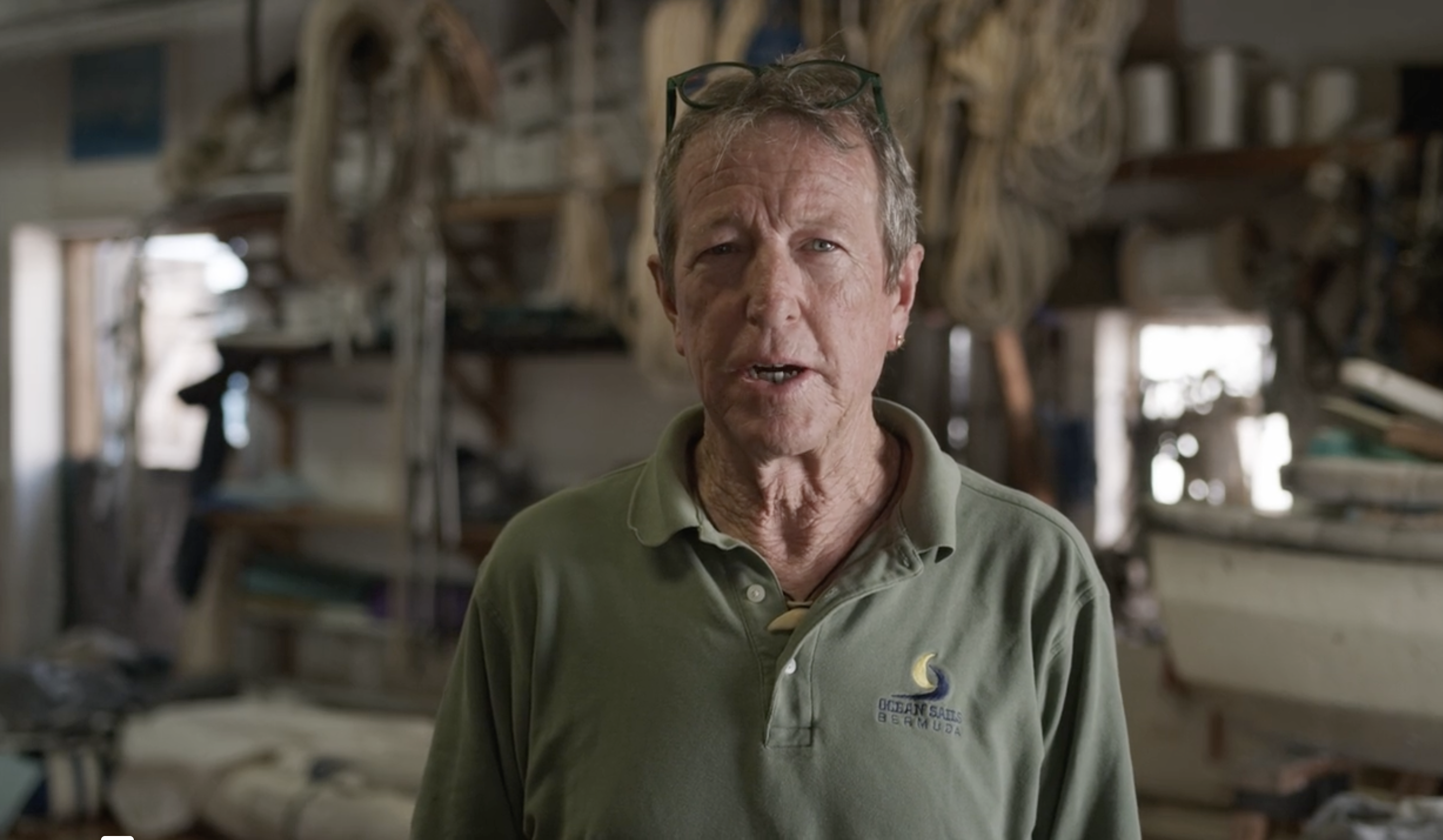 A man is talking to the camera in his workshop.