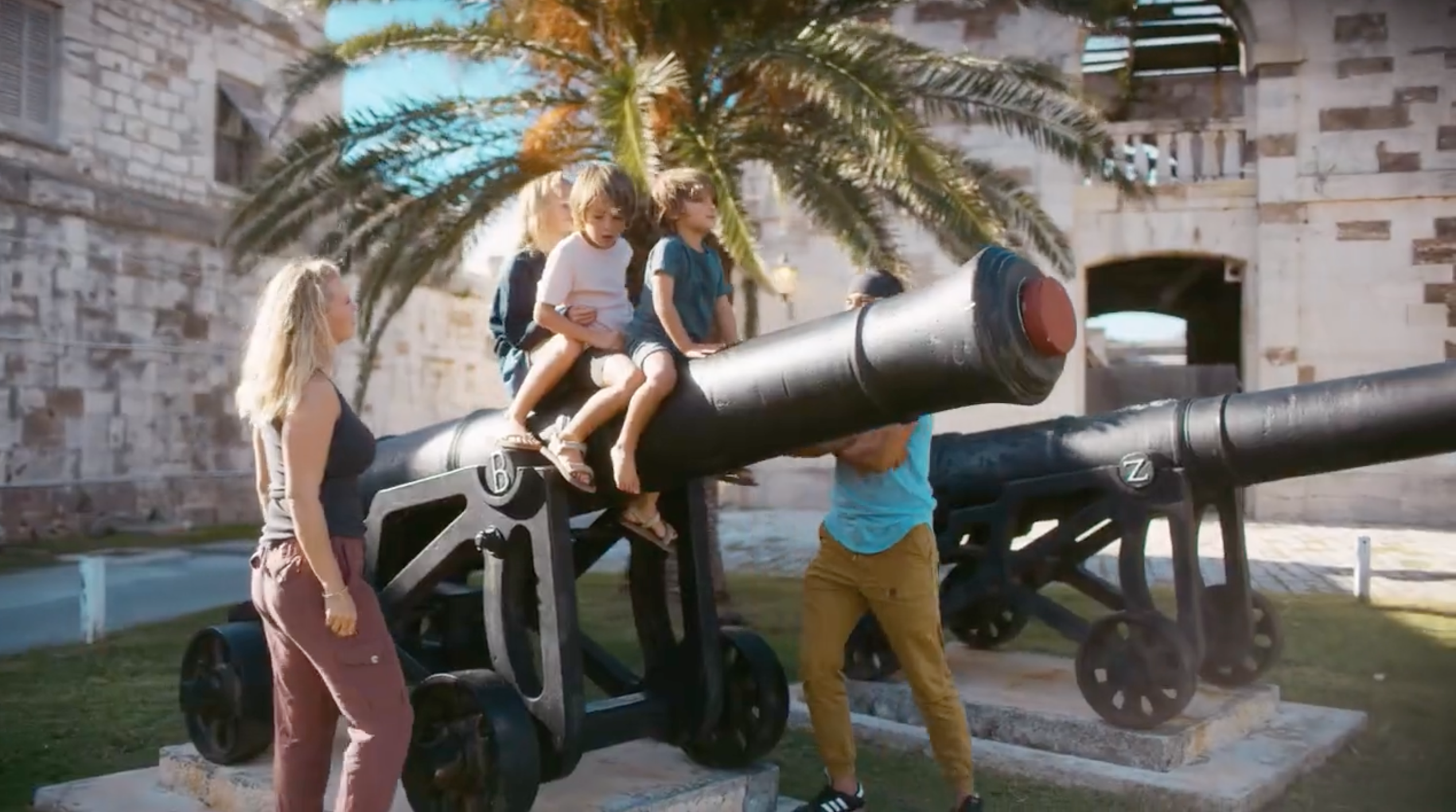 A family is standing by an old fort canon in Dockyard, Bermuda.