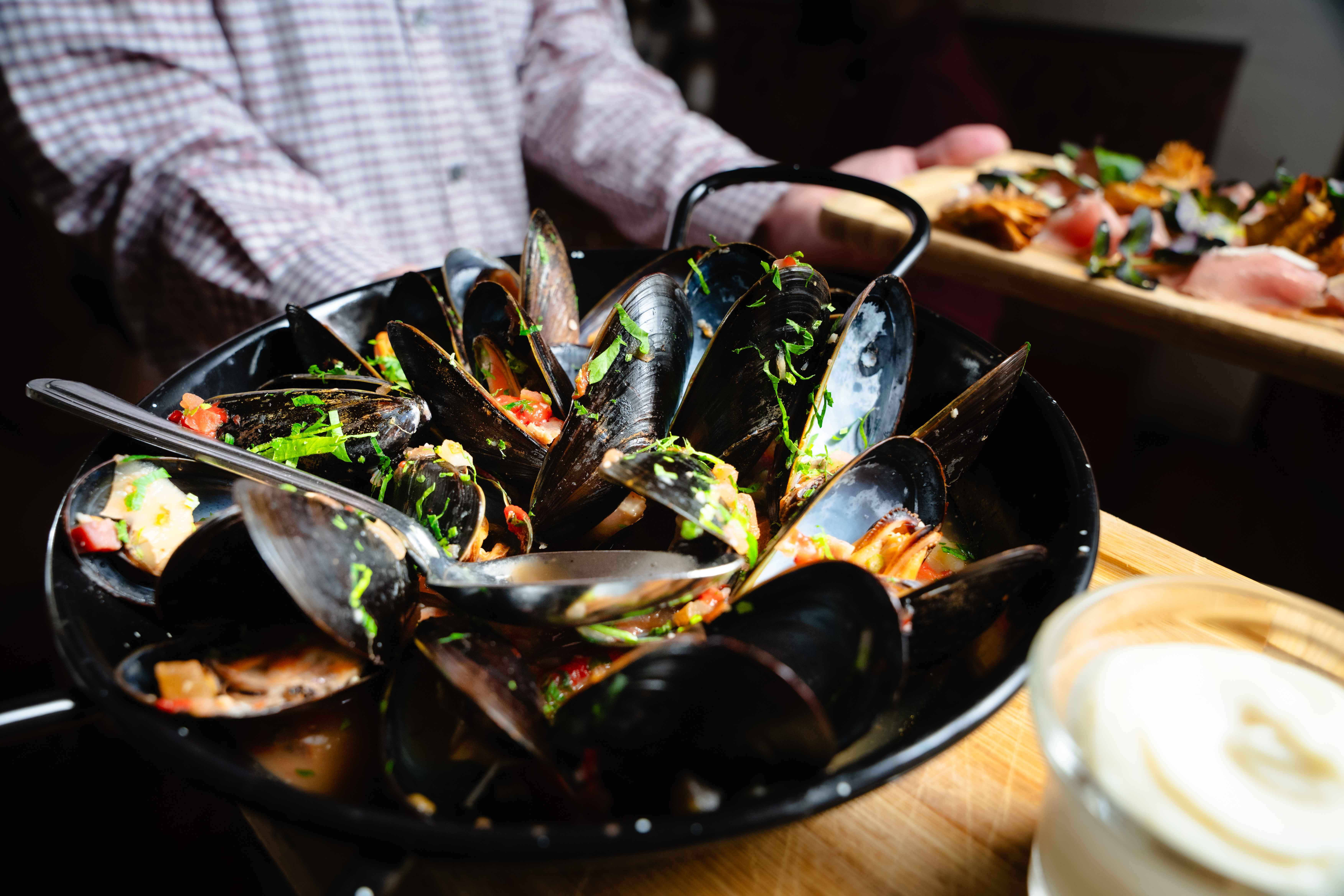 A close up of a plate of mussels. 