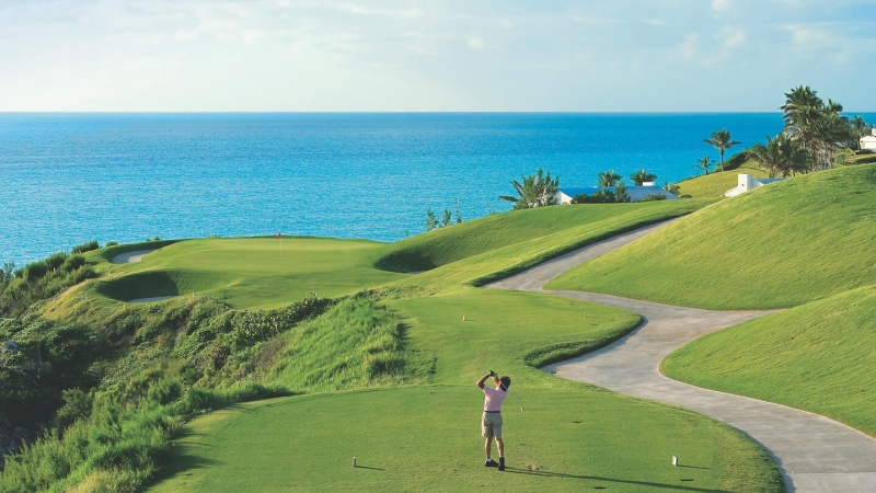 Man teeing off at Port Royal Golf Course with a view of the ocean