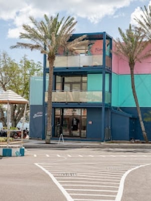 A colorful building with palm trees surrounding it.