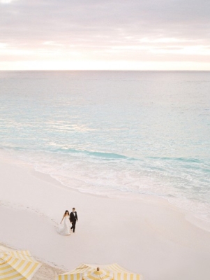 bride and groom walking on a beach