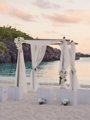 A wedding arch on a beach at sunset