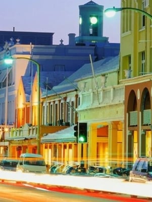 Street view at night with cars parked on the side of the road