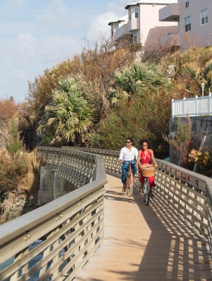 couple biking along a coastal section of the railway trail