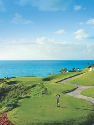 Man teeing off at Port Royal Golf Course with a view of the ocean