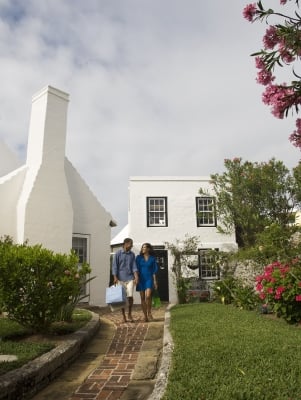 A couple leaves a store with shopping bags in hand in St. George’s, Bermuda.