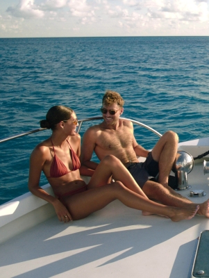 A couple is sitting on a boat smiling.