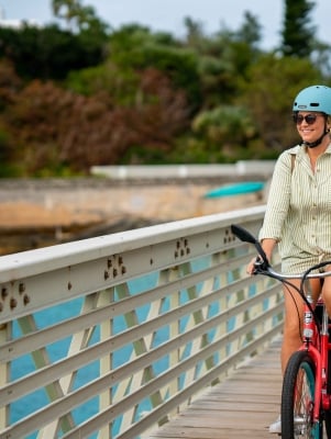 A woman in cycling along a railway trail.