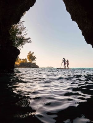 A couple is paddle boarding at Admiralty House