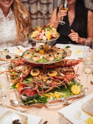 A table is filled with a lobster platter. 
