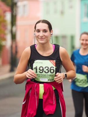 A woman is smiling while running a marathon.