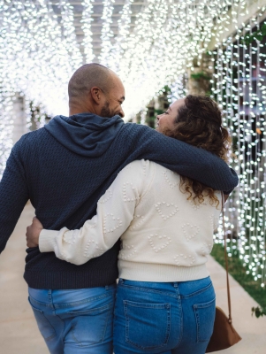 A couple is walking down a lighted alley.