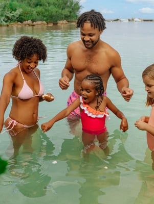 A family is in the water feeding fish.