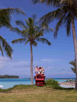 A group of friends are posing on a large chair.