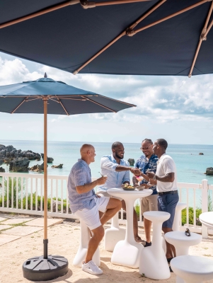 A group of guys are smiling by a scenic view.
