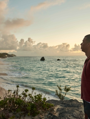 A man is posing by the beach