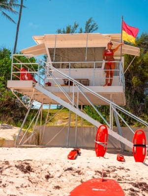 A life guard is pointing to the sea.