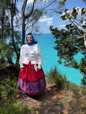 A woman is posing in traditional portuguese regalia.