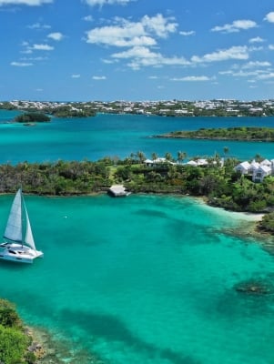 An aerial view of a sail boat in blue waters. 