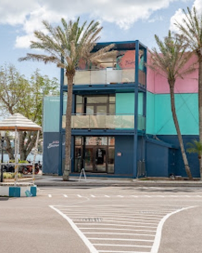 A colorful building with palm trees surrounding it.