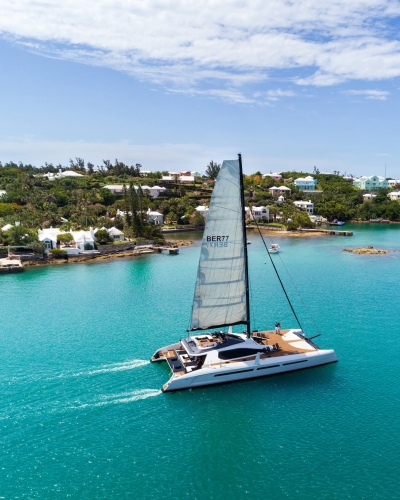 private sail boat gliding along the coastline