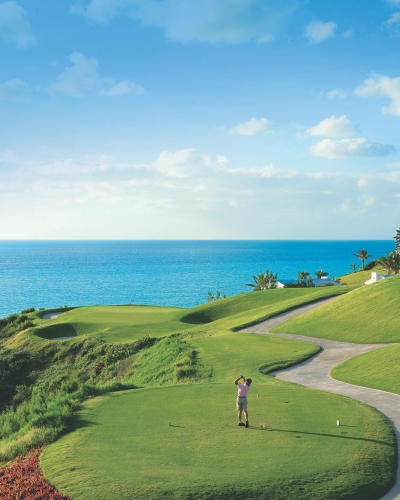 Man teeing off at Port Royal Golf Course with a view of the ocean