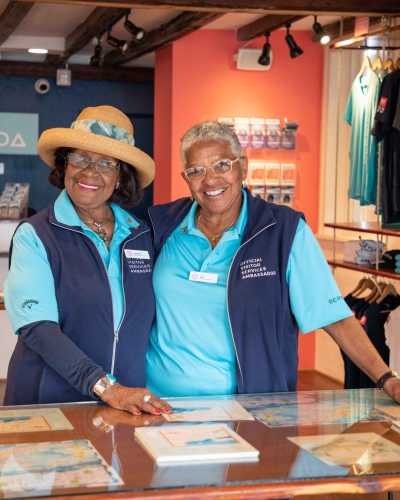 Two elderly women are smiling at the camera.