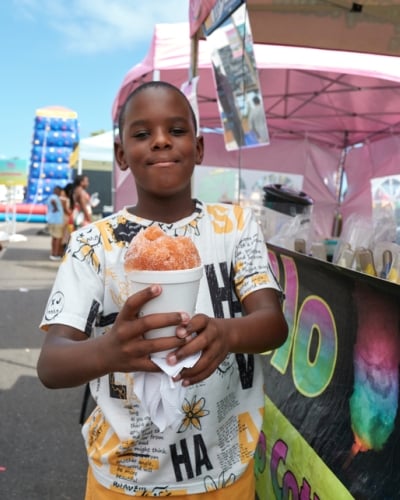 A young boy is holding a snowcone.