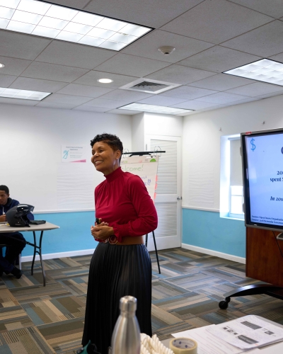 A woman is smiling teaching a class.