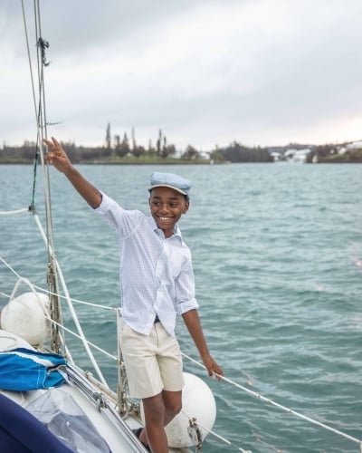 A little boy is smiling while walking on a boat.