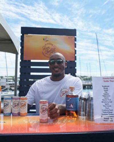 A man is holding a can of Bermuda rum swizzle. 